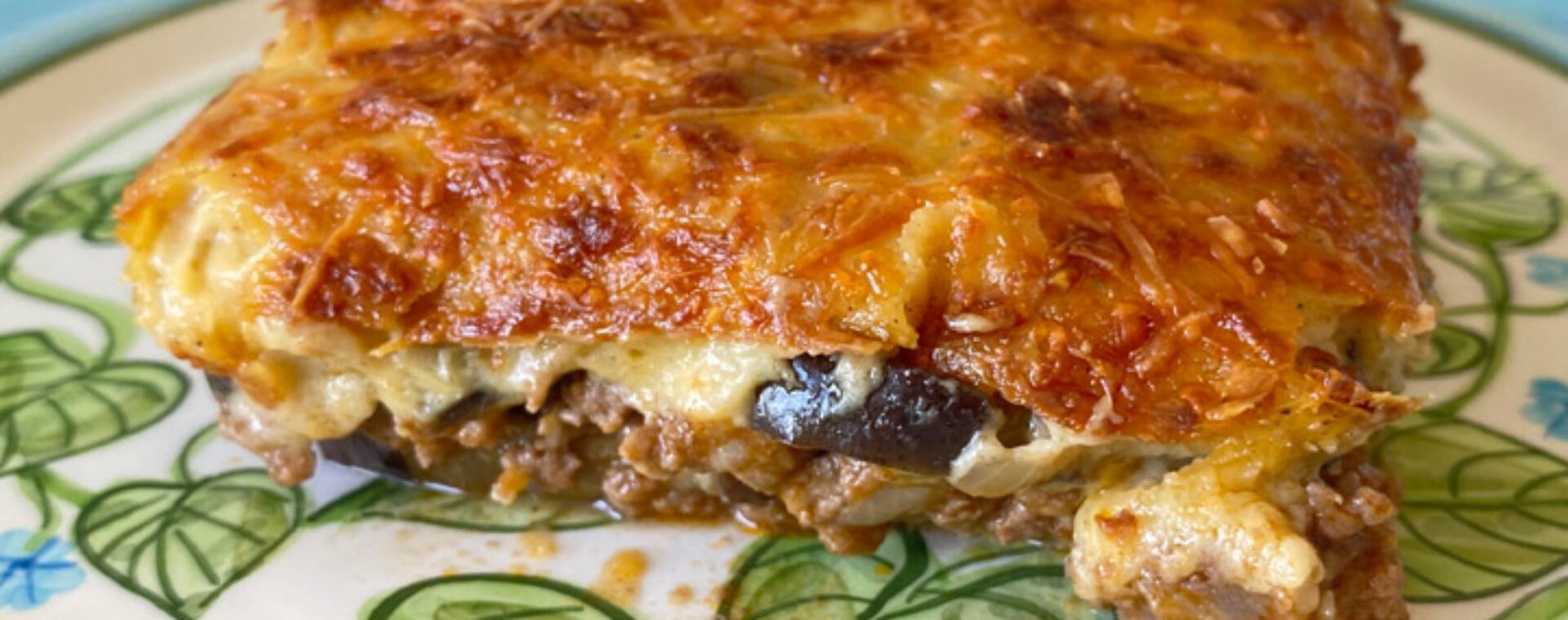 Moussaka, un plato preparado con capas de berenjenas, salsa de carne molida, y gratinado al horno con bechamel y queso parmesano.